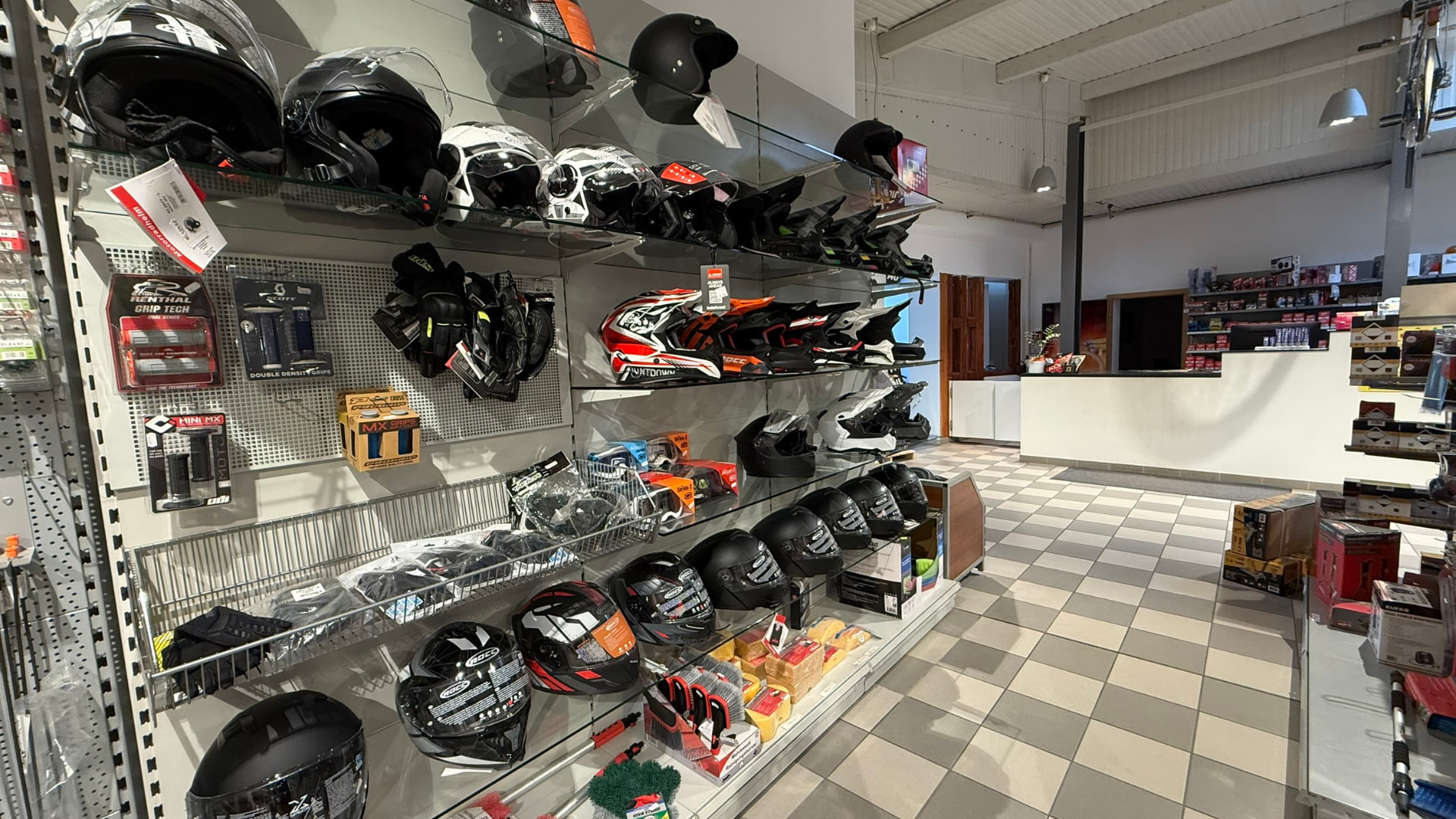 Motorradhelme, Handschuhe und Griffe in der Zubehör-Vitrine