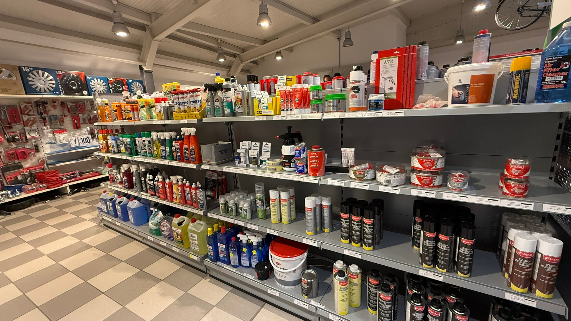 Regale mit Autopflege, Sprays, Radkappen und Werkstattbedarf